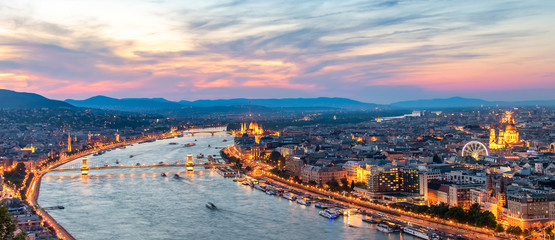 Aerial view of Budapest, Hungary with clouds. Buda castle, Chain bridge and Parliament building at sunset with lights on