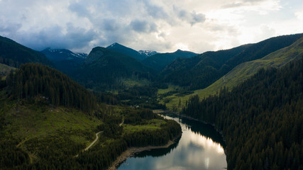 Obraz premium Aerial drone shot of a lake and green forest in Transylvania, Romania