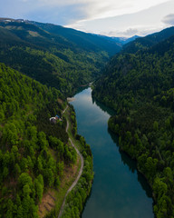 Fototapeta na wymiar Aerial drone shot of a lake and green forest in Transylvania, Romania