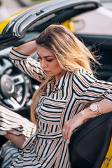 female driver in a sports yellow convertible car