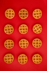 round little Viennese waffles on a red background top view. Sweet background