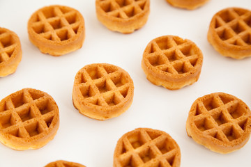 round little Viennese waffles on a white background top in perspective. Cookies background,close up.