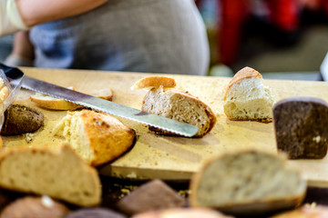 Wooden cutting board with sliced homemade bread and knife.