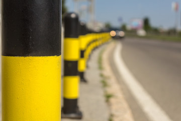 long line of yellow and black traffic signs to deter the cars around the road.