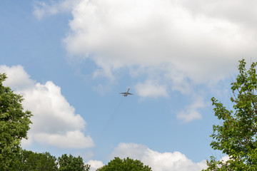 Airplane on a blue sky with soft white clouds.