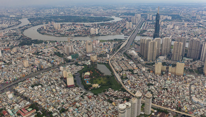 Fototapeta na wymiar Top View of Building in a City - Aerial view Skyscrapers flying by drone of Ho Chi Mi City with development buildings, transportation, energy power infrastructure.