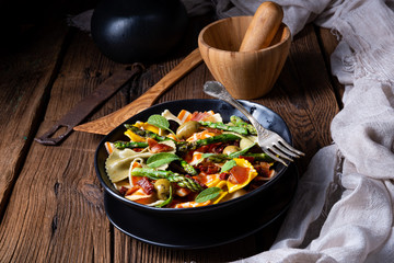 Pasta salad with green asparagus, olives and parma ham