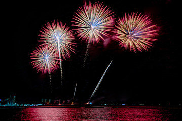 Amazing beautiful colorful fireworks display on celebration night, showing on the sea beach with...