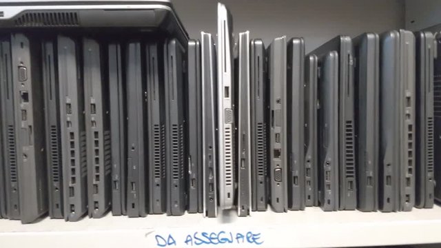 panning sot of many laptops stored on the shelf in service shop ready to be checked and fixed