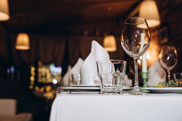 Beautiful decorated elegant wedding table for dinner with floral white bouquets, candlesticks and a...