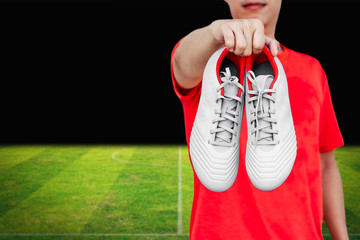 Man holding white football boots in his hand.