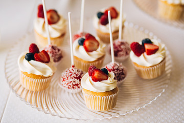 Beautiful cake covered with icing cream, summer berries on the top. Style and food photography
