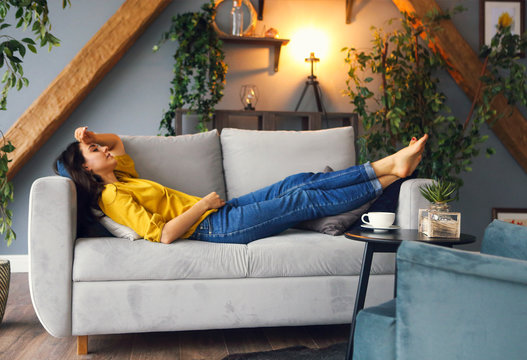 Young brunette woman relaxing on the couch after a long day
