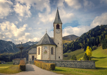 Fototapeta na wymiar Autumn view with dramatic clouds on Small church in tiny village near Lake Braies Park (Lago di Braies). South Tyrol. Italy. Europe