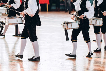 Obraz premium A closeup of the hands of a drummer at a parade. Children's ensemble in white shirts. White new snare drum, white sticks. The concept of a military parade and march.