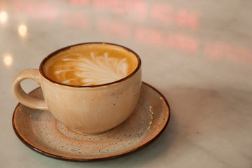 Cup of cappuccino with beautiful latte art on a table in a cafe with copyspace.