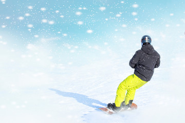 Fototapeta na wymiar Snowboarder in bright sportswear doing trick against of beautiful winter background