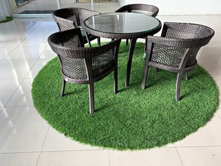 interior furniture, table set for dining decorating with artificial grass circle shape on the floor, interior design decoration concept in the building. 