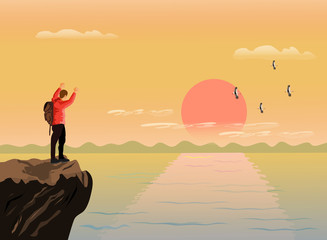 The man stood up and showed his hands on the top of the mountain happily. There are sea, mountains and sunset background