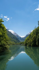 Beautiful scenery of Klammsee in Austrian alps with snowy mountains behind