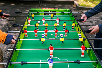 A game of table football. Two people playing table football outside. Entertainment during holidays or free time. Young people on holiday in summer