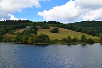 Fototapeta premium Farm field meadow on hill next to lake nature landscape