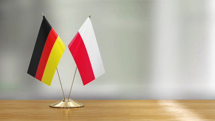 Polish and German flag pair on a desk over defocused background  - 271400918