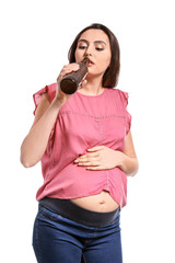 Pregnant woman drinking beer on white background