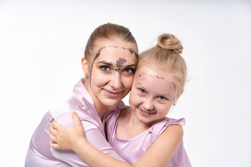 young mothers and young daughter Europeans conduct facial skin care procedures. Family treatments. Cosmetic skin care.