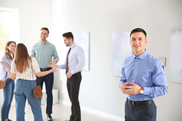 Young man at exhibition in modern art gallery