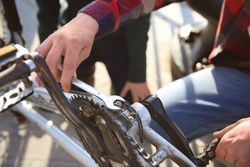 Father and his son repairing bicycle outdoors, closeup