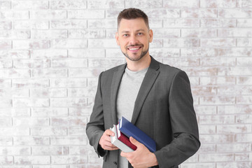 Handsome male teacher against brick wall