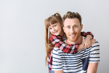 Portrait of happy father and daughter on light background