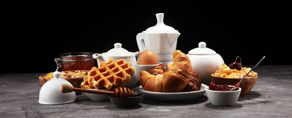 Huge healthy breakfast on table with coffee, orange juice, fruits, waffles and croissants. Good morning concept.