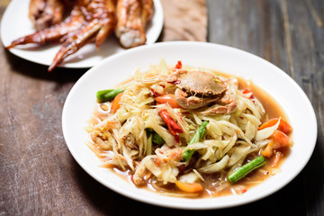 Spicy papaya salad and grilled chicken wing. Thai food (Som Tum)