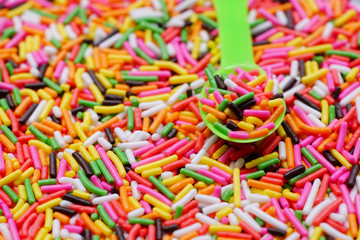 Fototapeta na wymiar colorful sugar sprinkles on plastic spoon