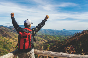 Traveler Man with backpack hands raised mountains landscape on background.