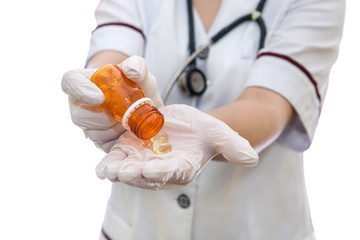 Doctor's hands in gloves with bottle and yellow capsules