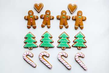 Handmade festive gingerbread cookies in the form of stars, snowflakes, people, socks, staff, mittens, Christmas trees, hearts for xmas and new year holiday on white paper background
