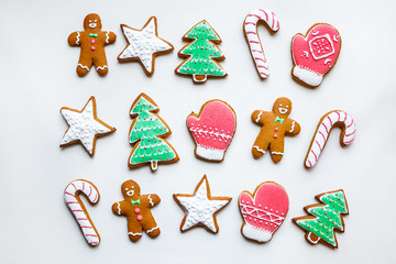 Obraz na płótnie Canvas Handmade festive gingerbread cookies in the form of stars, snowflakes, people, socks, staff, mittens, Christmas trees, hearts for xmas and new year holiday on white paper background
