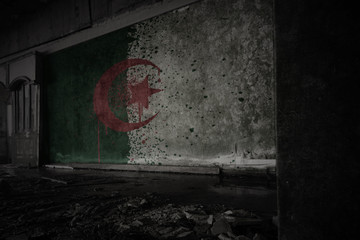 painted flag of algeria on the dirty old wall in an abandoned ruined house.