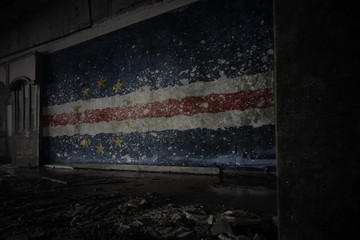 painted flag of cape verde on the dirty old wall in an abandoned ruined house.