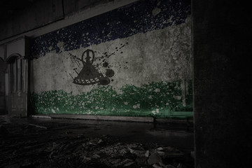 Fototapeta na wymiar painted flag of lesotho on the dirty old wall in an abandoned ruined house.