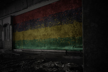 painted flag of mauritius on the dirty old wall in an abandoned ruined house.