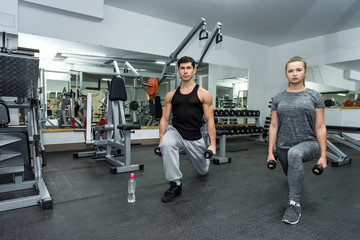 Fototapeta na wymiar Two people in gym making exercise together