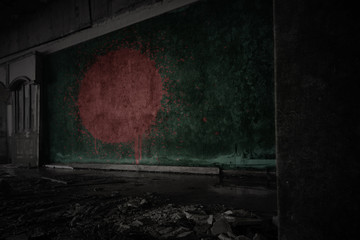 painted flag of bangladesh on the dirty old wall in an abandoned ruined house.