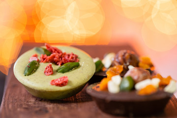 Christmas theme. Handmade chocolates candy. Mini chocolate dessert covered with nuts and dried fruits. Garland lamps bokeh on background. Copy space