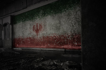 painted flag of iran on the dirty old wall in an abandoned ruined house.