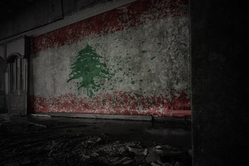 painted flag of lebanon on the dirty old wall in an abandoned ruined house.