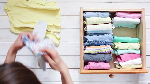 Marie Kondo tyding up method concept - folding kids clothes, top view